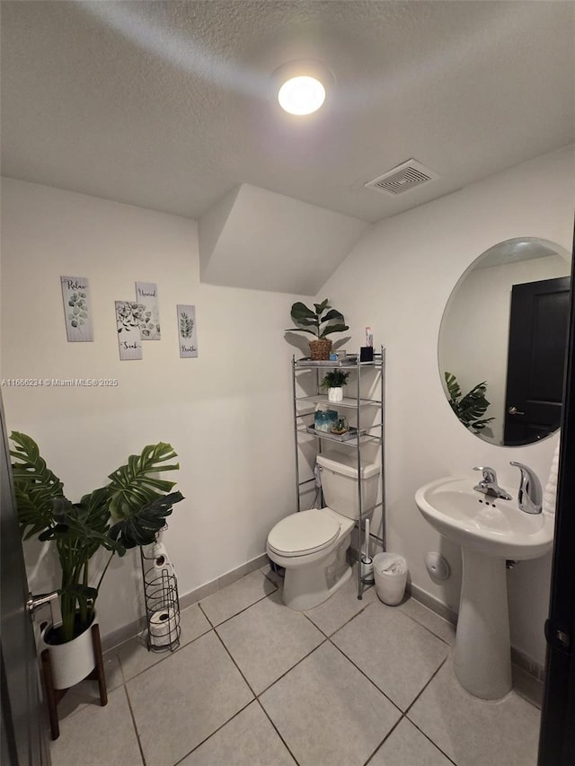 bathroom featuring tile patterned flooring, a textured ceiling, toilet, and vaulted ceiling