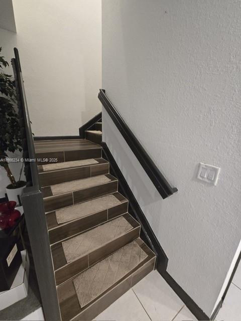 staircase with tile patterned floors