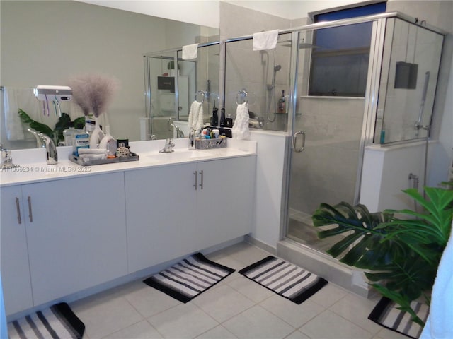 bathroom with tile patterned flooring, vanity, and a shower with door