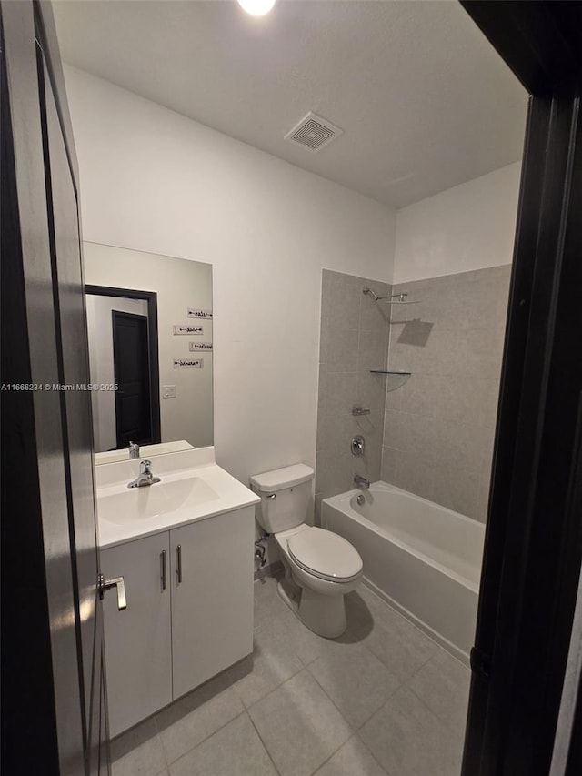 full bathroom featuring tile patterned flooring, toilet, vanity, and tiled shower / bath