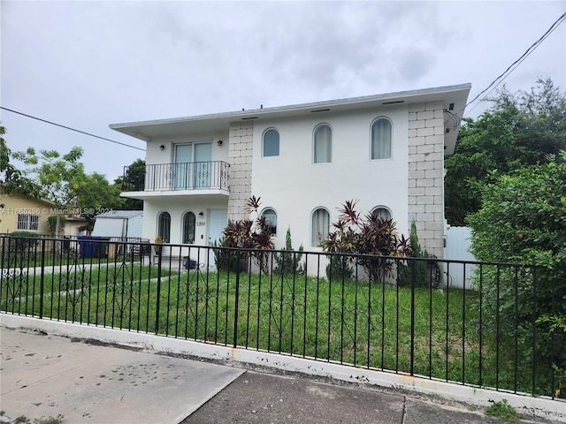 view of front of property with a balcony and a front yard