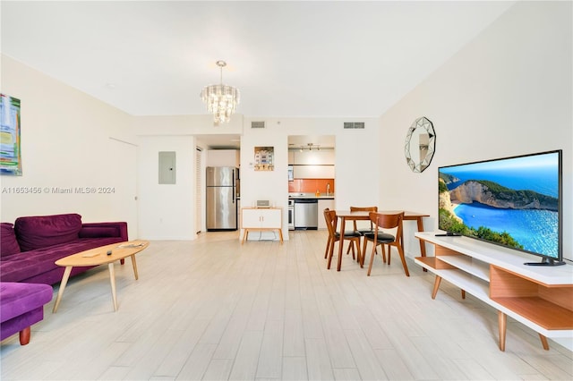 living room featuring light hardwood / wood-style flooring, electric panel, an inviting chandelier, and sink