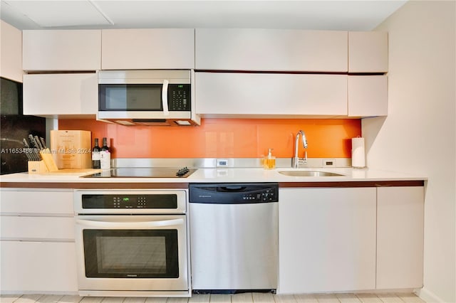 kitchen featuring white cabinets, appliances with stainless steel finishes, and sink