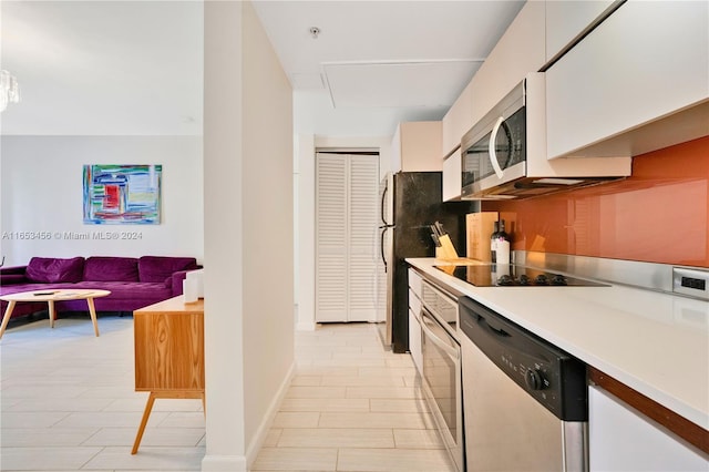 kitchen featuring stainless steel appliances and white cabinets