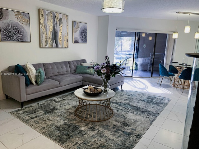 living area featuring marble finish floor and a textured ceiling