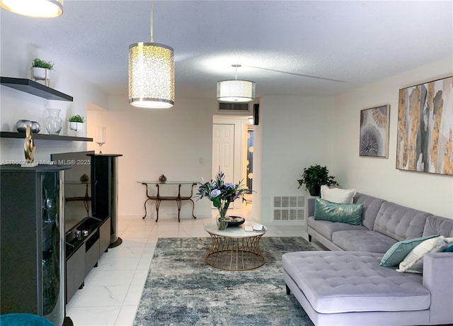 living room featuring marble finish floor, visible vents, and a textured ceiling