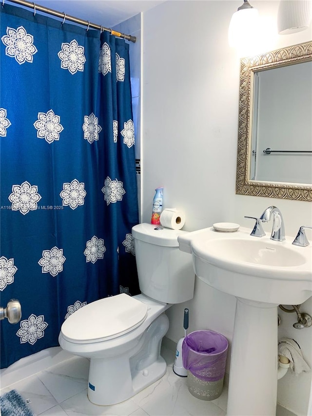 bathroom featuring a shower with curtain and toilet