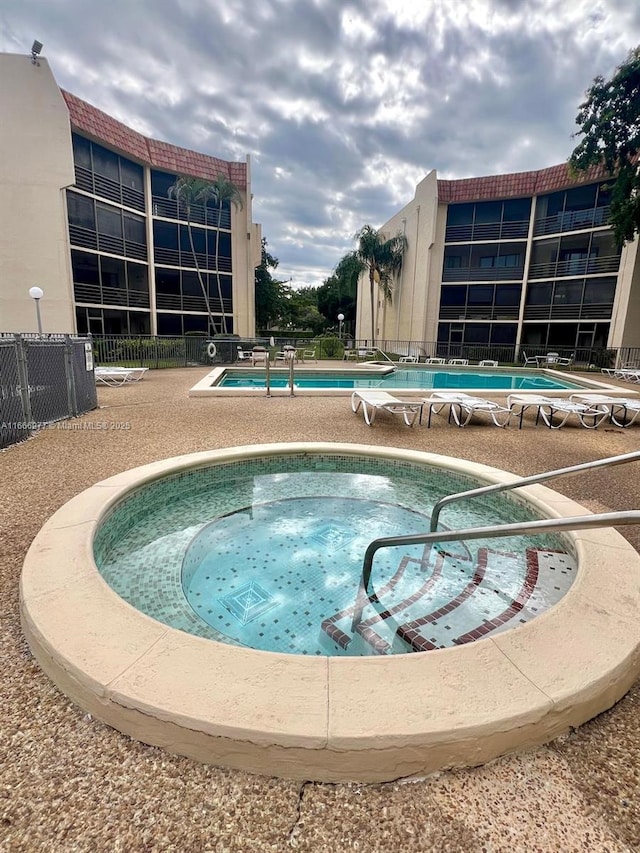 view of pool with a hot tub