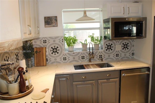 kitchen with stainless steel appliances, tasteful backsplash, gray cabinetry, and sink