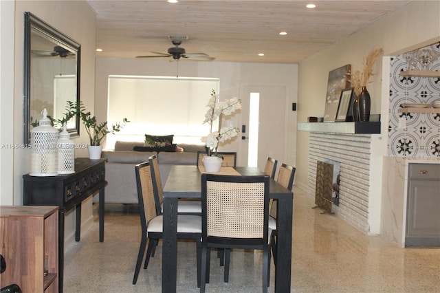 dining area with ceiling fan and a fireplace