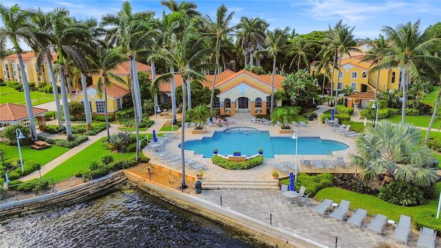 view of swimming pool featuring a jacuzzi, a water view, and a patio area