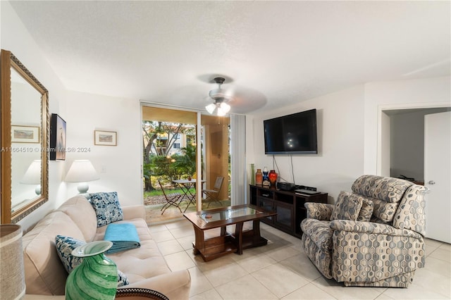 living room featuring ceiling fan, a textured ceiling, and light tile patterned flooring