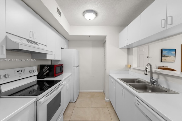 kitchen with white cabinets, a textured ceiling, sink, light tile patterned flooring, and white appliances