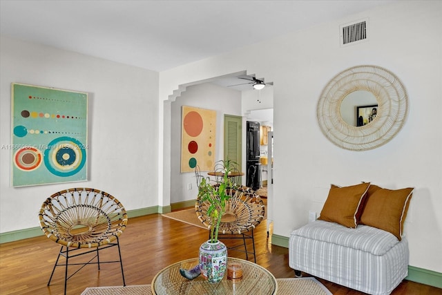 living room with ceiling fan and dark wood-type flooring