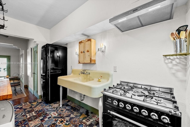 kitchen featuring range with gas stovetop, dark hardwood / wood-style flooring, ventilation hood, light brown cabinetry, and sink