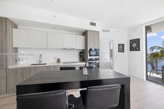 kitchen featuring white cabinets, sink, and black appliances