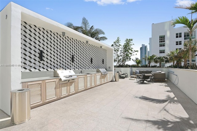 view of patio / terrace featuring grilling area, an outdoor living space, sink, and exterior kitchen