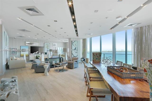 dining space featuring light wood-type flooring and floor to ceiling windows