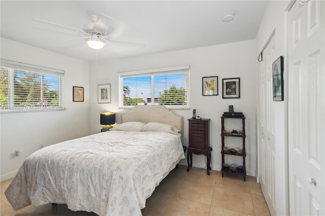 tiled bedroom featuring ceiling fan and a closet