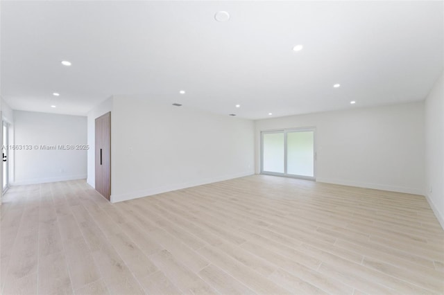 empty room featuring light wood-style floors, baseboards, and recessed lighting