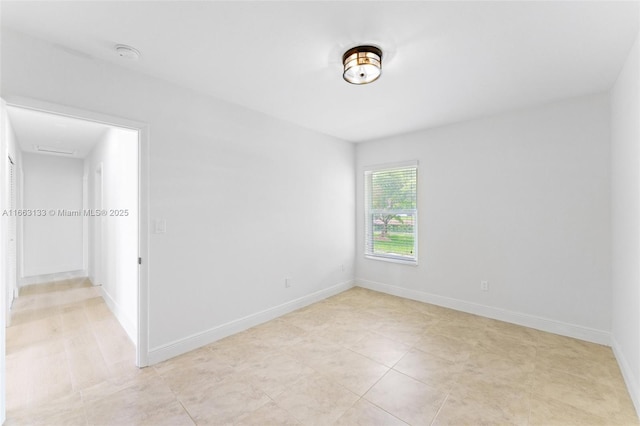 unfurnished room with baseboards