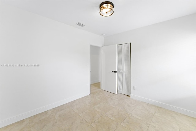 unfurnished room featuring baseboards and visible vents