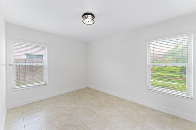 unfurnished room with baseboards