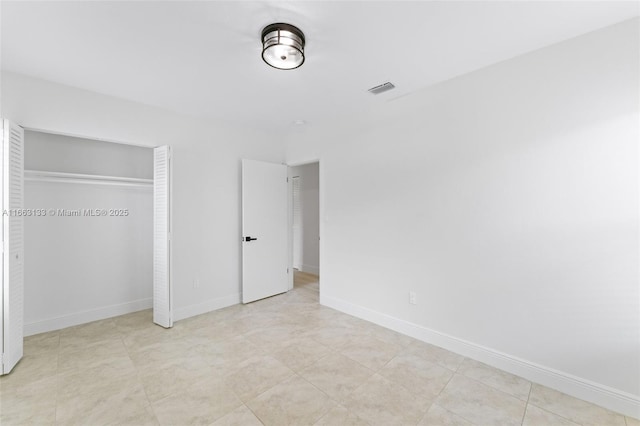 unfurnished bedroom with baseboards, visible vents, and a closet