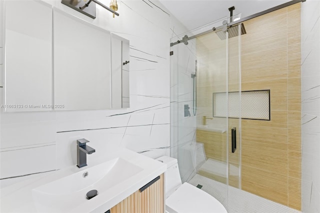 bathroom with tile walls, tasteful backsplash, toilet, a stall shower, and vanity