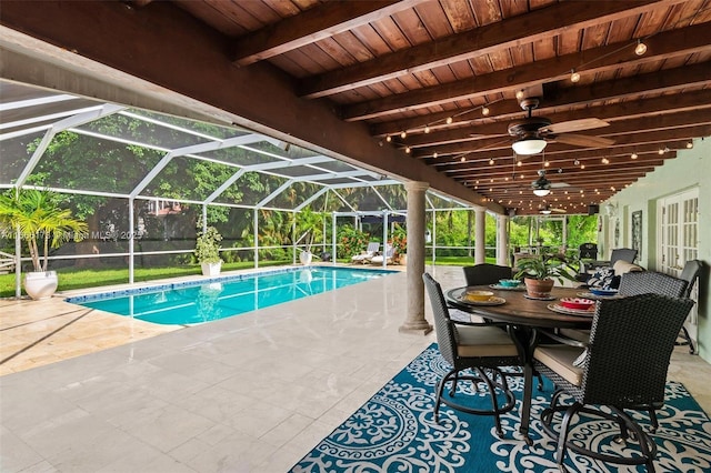 view of swimming pool featuring a patio area, glass enclosure, and ceiling fan