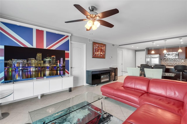 living room with ceiling fan, light tile patterned floors, and crown molding