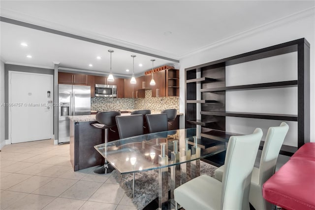 dining room with light tile patterned flooring and crown molding