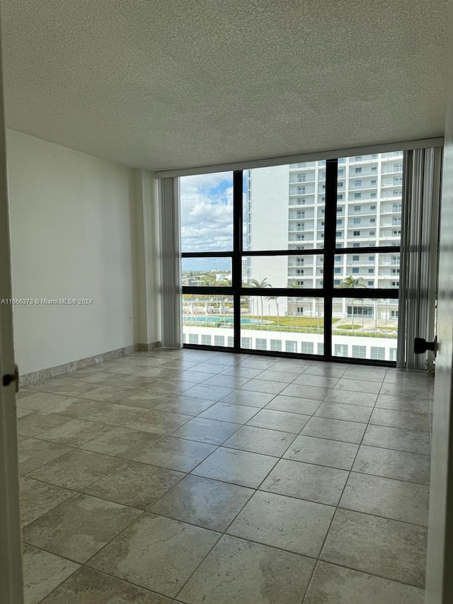 empty room featuring a textured ceiling and expansive windows