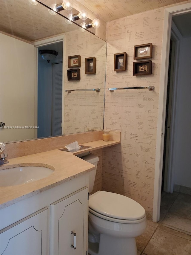 bathroom with tile patterned flooring, vanity, and toilet