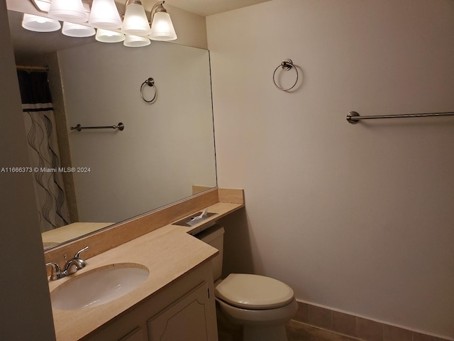 bathroom featuring tile patterned flooring, vanity, and toilet