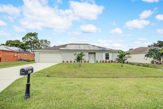 ranch-style home with a front lawn, solar panels, and a garage