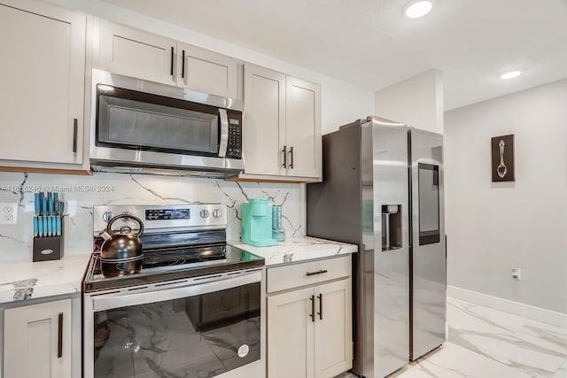 kitchen featuring backsplash, stainless steel appliances, and light stone counters