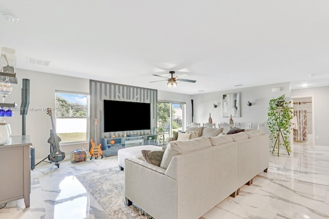 living room featuring ceiling fan and plenty of natural light