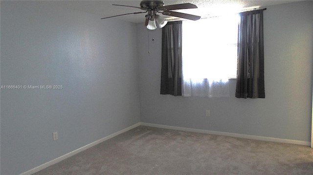 empty room featuring light carpet, baseboards, and a ceiling fan