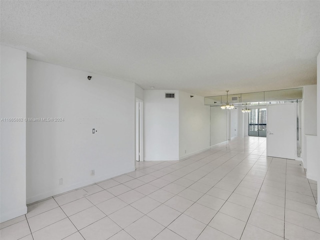 tiled empty room with a textured ceiling