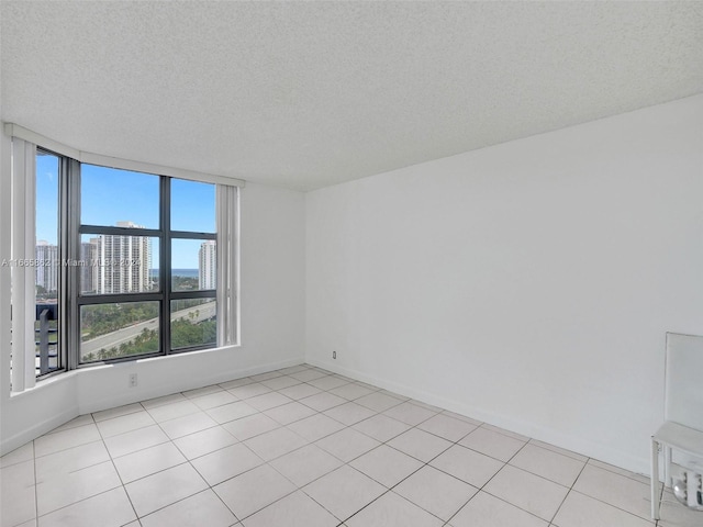 empty room featuring a textured ceiling and light tile patterned floors