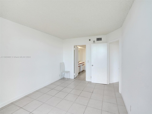 tiled spare room with a textured ceiling