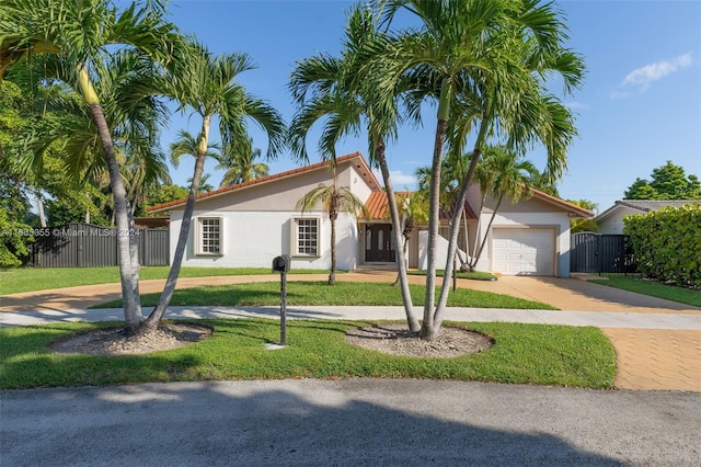 view of front of house with a garage and a front lawn