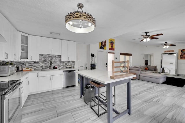 kitchen featuring stove, ceiling fan, decorative light fixtures, dishwasher, and white cabinetry