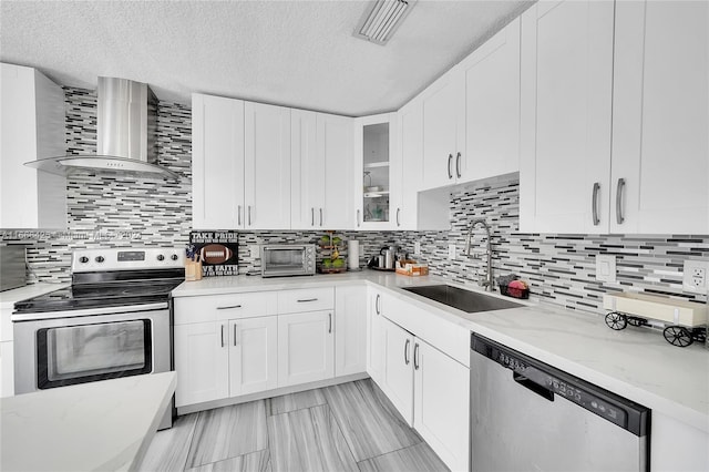 kitchen with white cabinets, sink, wall chimney exhaust hood, and appliances with stainless steel finishes