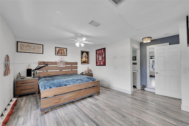 bedroom featuring ceiling fan, light wood-type flooring, and ensuite bath