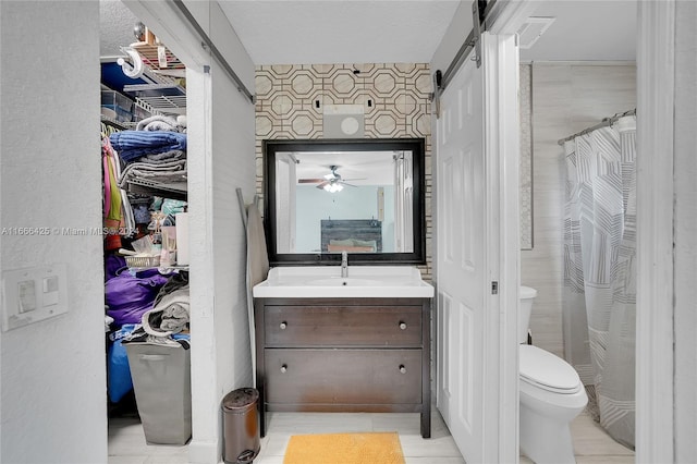 bathroom with vanity, a textured ceiling, toilet, and curtained shower