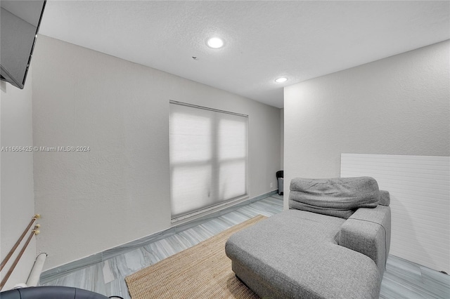 living area featuring a textured ceiling and light hardwood / wood-style flooring