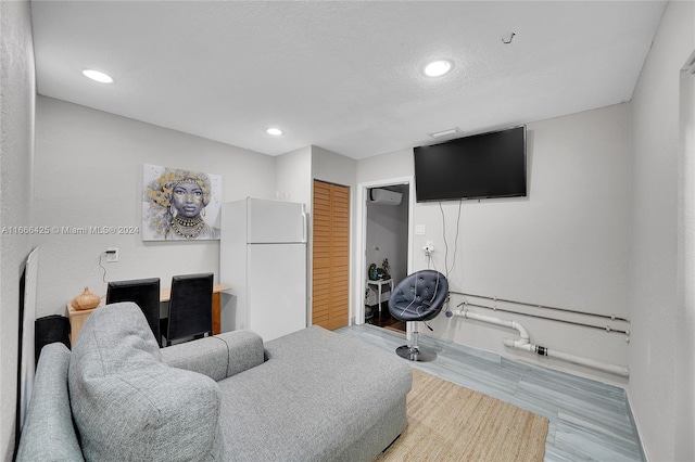 living room featuring hardwood / wood-style flooring and an AC wall unit