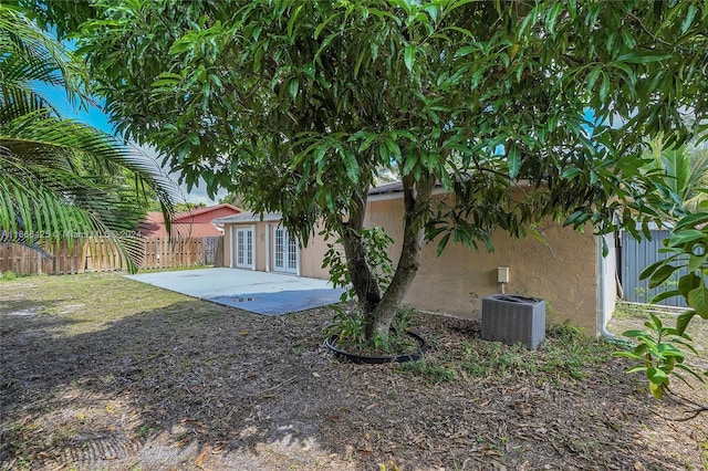 view of yard with french doors, a patio area, and central air condition unit